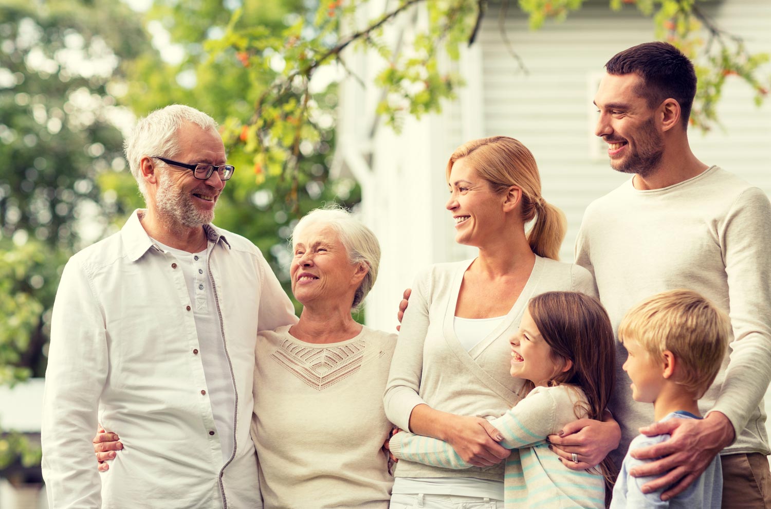 A happy family of grandparents and parents and boy and girl children in cozy sweater and shirts smiling together