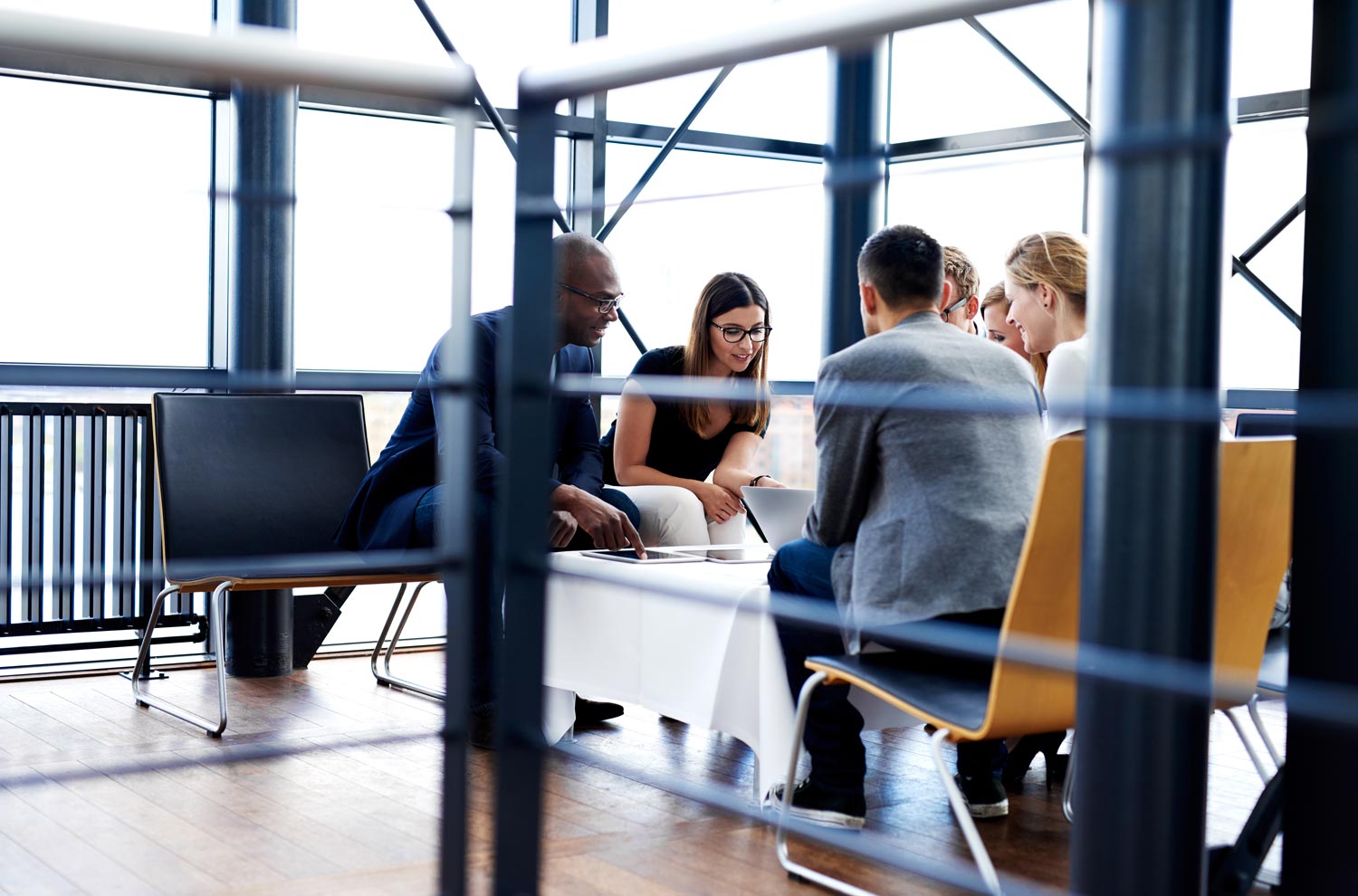 A group of people having a meeting on the lounge chairs at the office