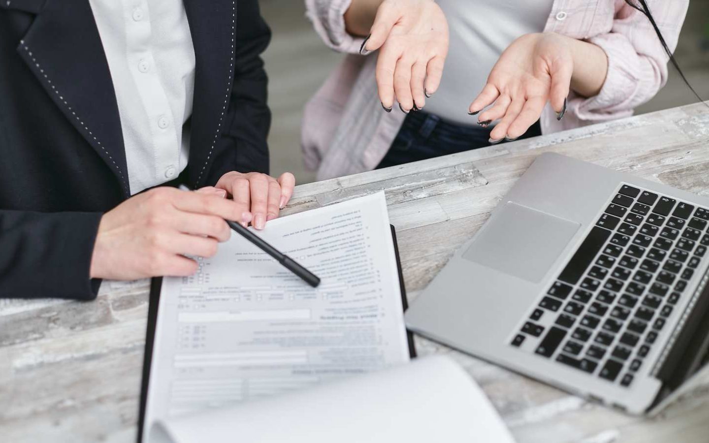 person using a pen to point out a line in a document